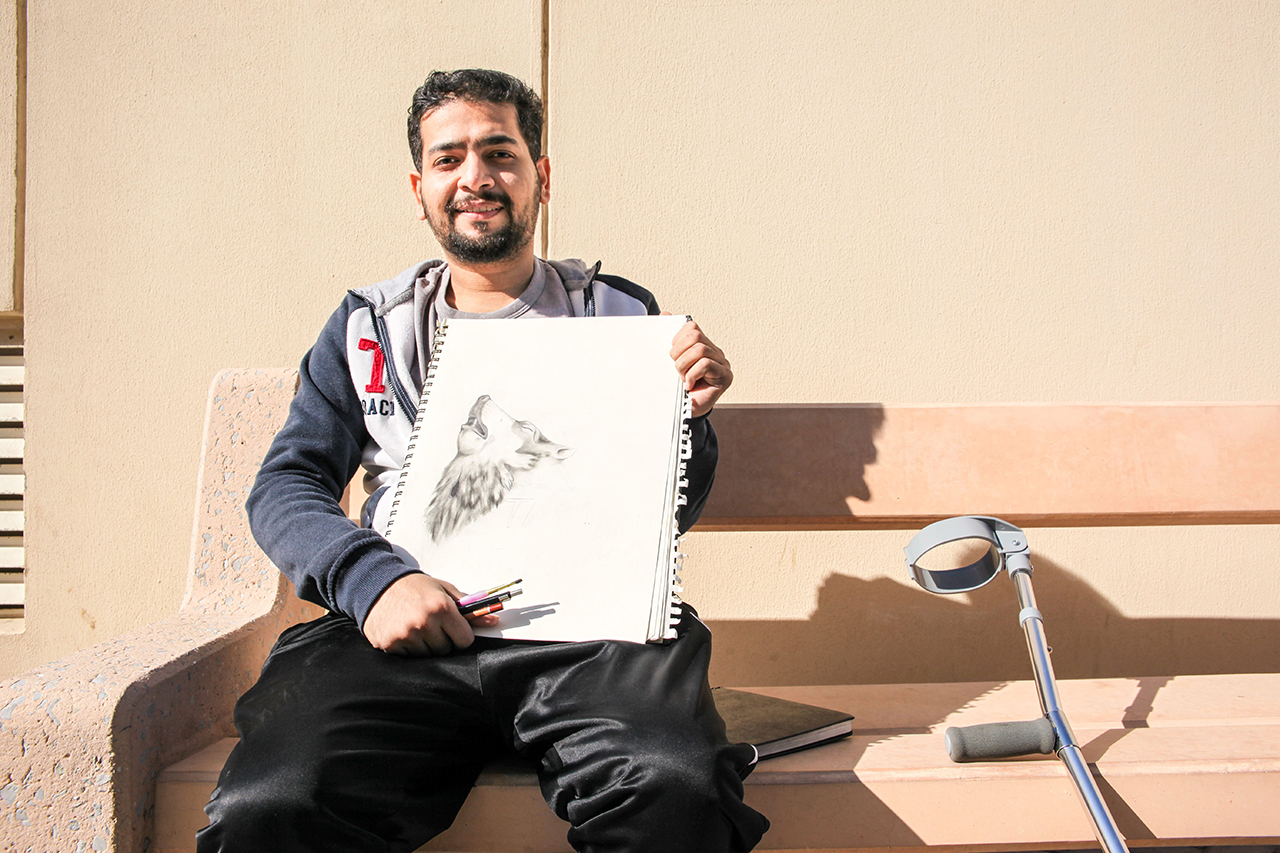 Ahmed montrant ses dessins. 